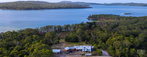 Daytime aerial view of Bruny Island Lodge, with Curlew Island in the D'Entrecasteaux Channel in the background